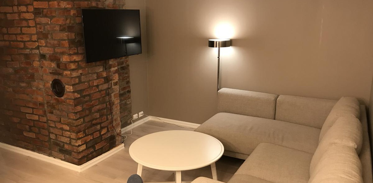 Stue med stor sofa, sofastol og tv