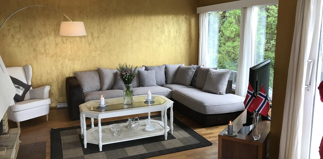 Nyoppusset stue med ny sofa, store vinduer til hagen