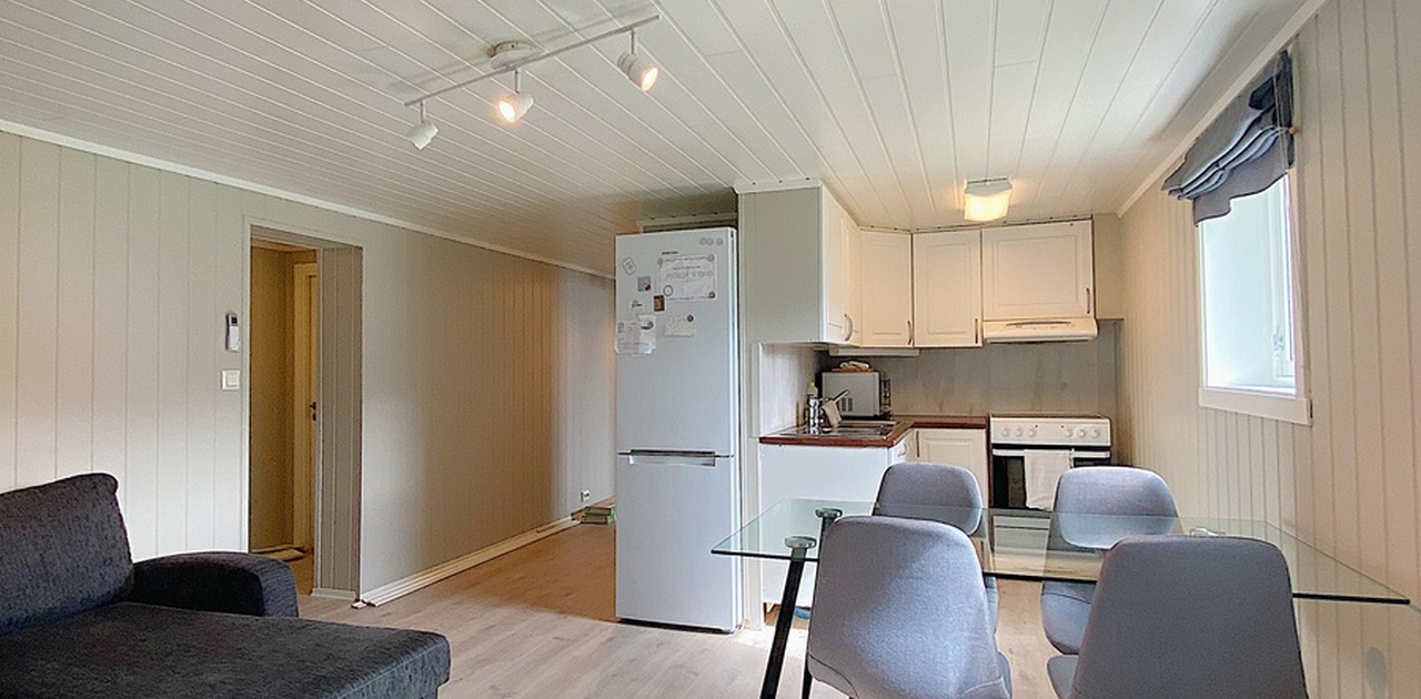 kjøkken med komfyr, kjøleskap, kjøkkenbord