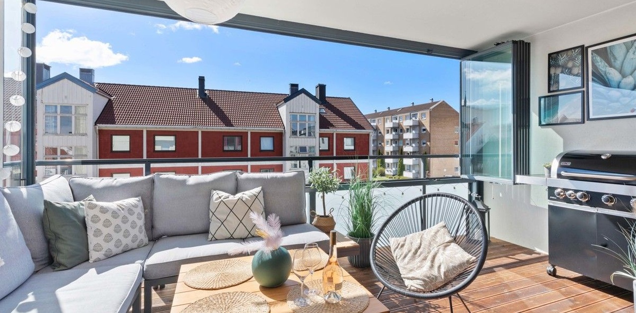 Solrik innglasset balkon med utemøblement