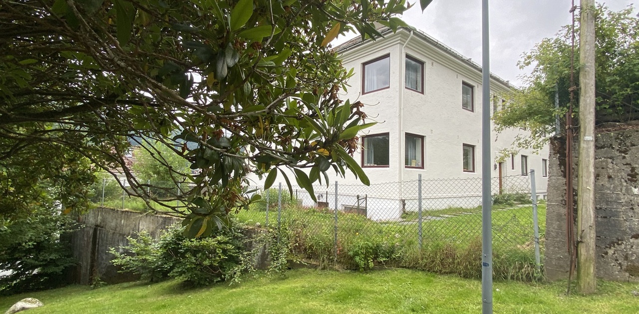Bygningen sett fra siden. Hjørne vinduene til det ledige rommet ser du øverst