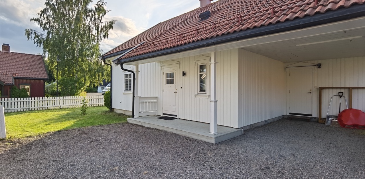 Forsiden av huset. Bod under carporten. 2 parkeringsplasser (1 under carporten og 1 til høyre for carporten)
