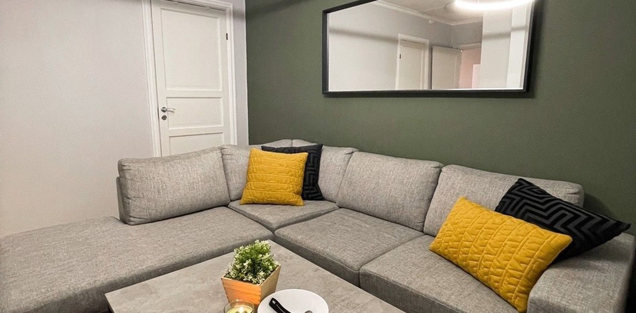 Koselig stue med stor sofa og TV. Moderne taklys som kan dimmes samt justere mellom varmt/kaldt lys.