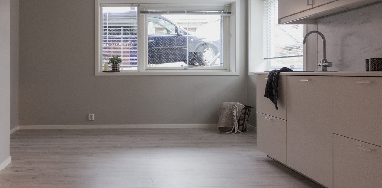 Stuehjørne og kjøkken med plass til både sofa og tv.