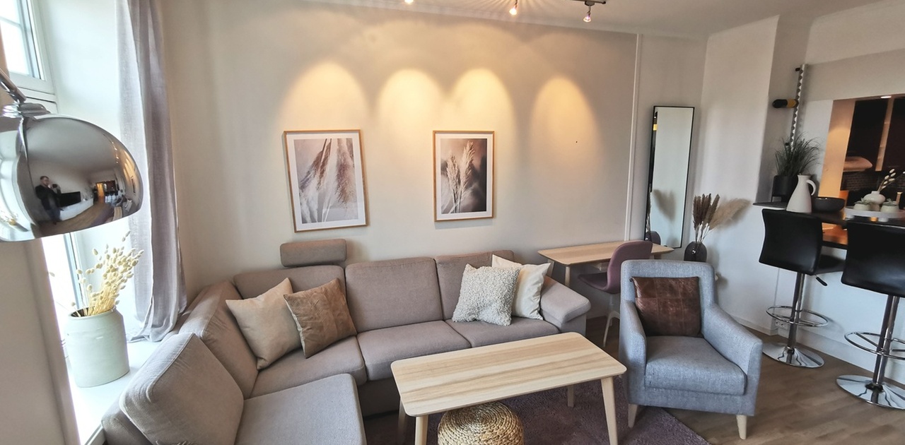 Lys stue med brede vinduskarmer og 270cm takhøyde. Sofa er inkludert. Nymalt med nytt gulv og gulvvarme i 2024