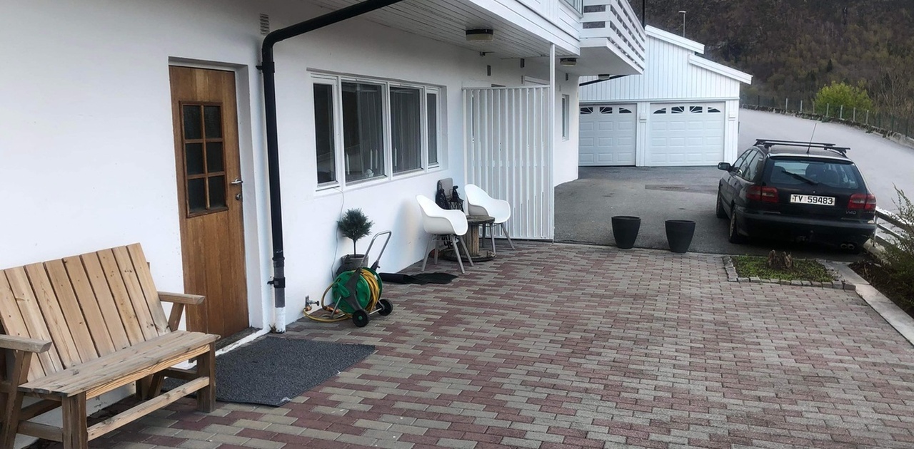 Inngang med utemøblar og parkeringsplass