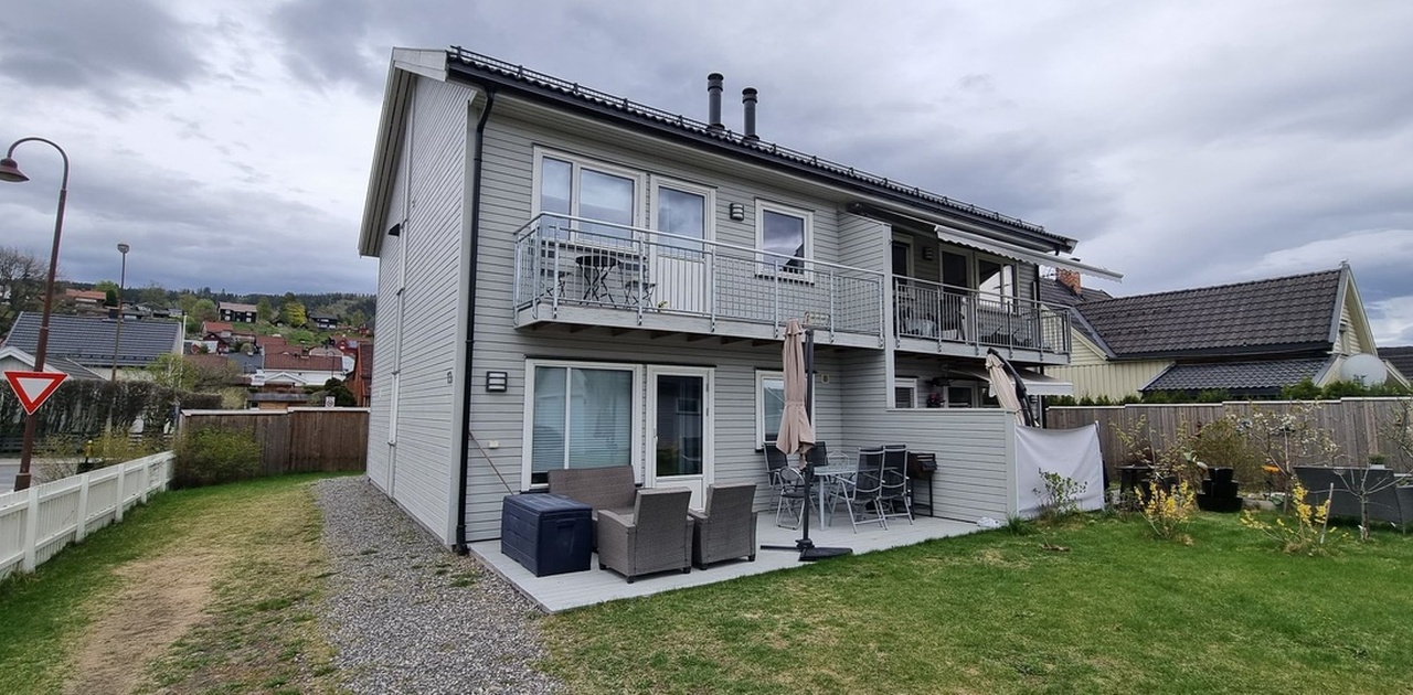 Terrasse foran huset med utemøbler og grill.