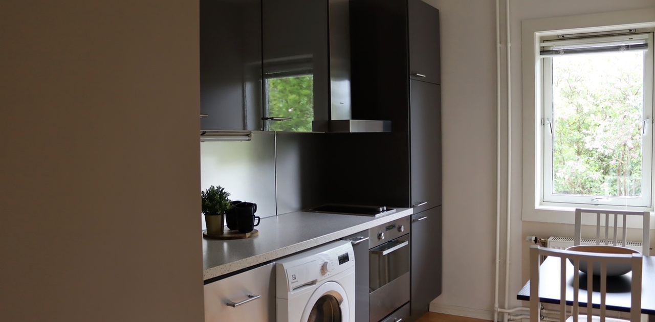 Kjøkken med inntegrert kjøleskap og oppvaskemaskin.