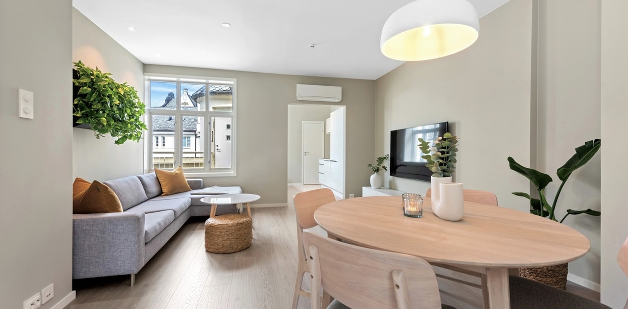 Romslig stue med spisegruppe og stor sofa