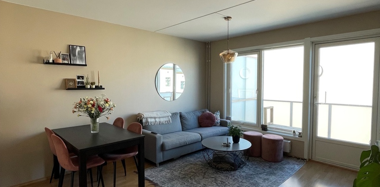 Romslig stue med sofaområde, spisebord og balkong