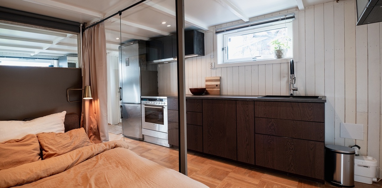 Vegg i glass gir en romslig følelse mellom sovealkove og kjøkken.