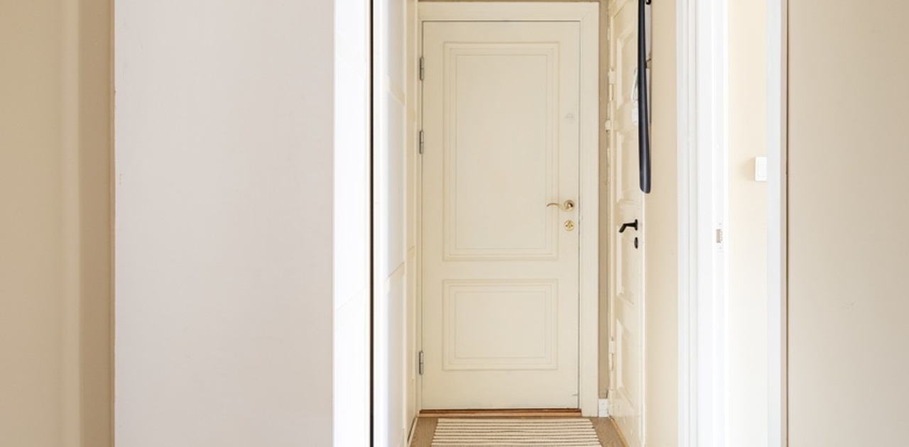 Romslig entré med skap og plass til kontorhjørne eller kommoder.