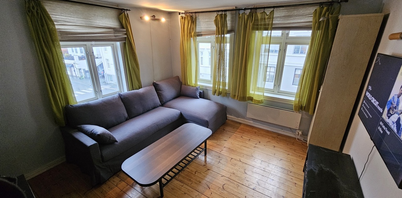 Lys stue med peis og store vindusflater