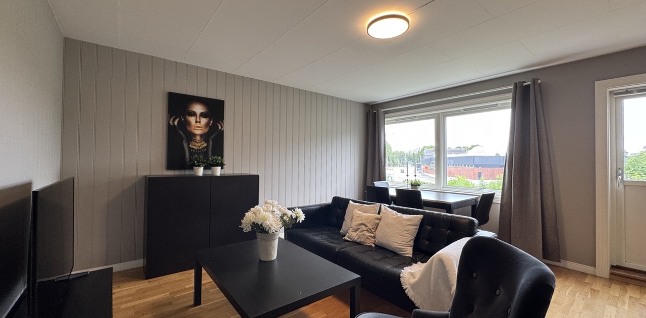 Flott stue med skap, sofa, stol og TV