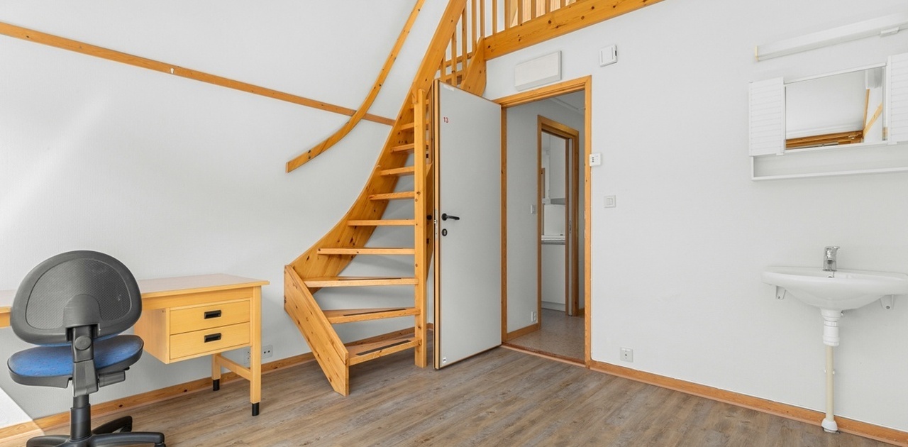 Rommet har stort areal, med egen hems for seng.