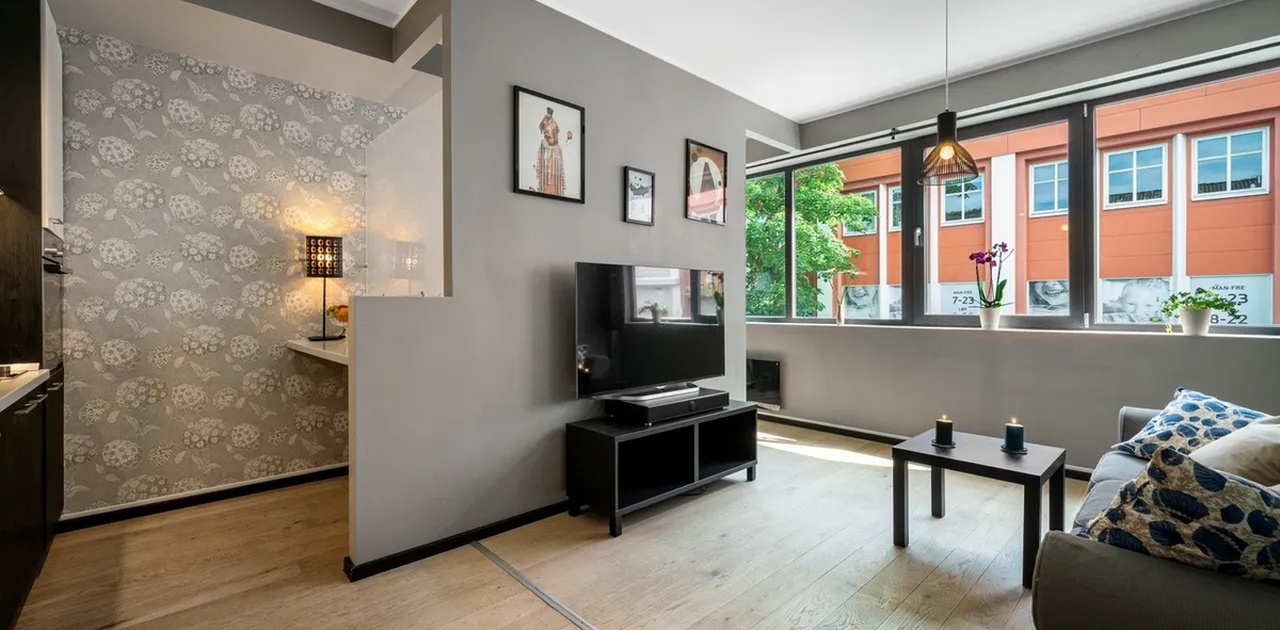 Stuen har plass til sofa med tilhørende møblement og det er også lagt opp til arbeidsstasjon eller hjemmekontor -