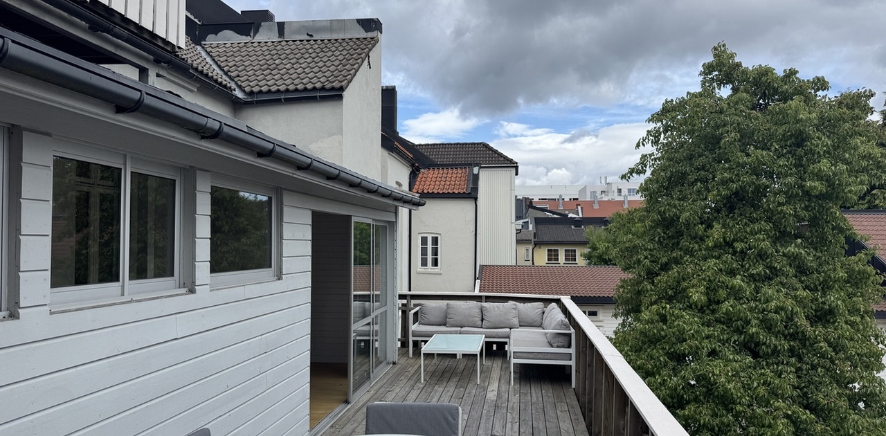 Solrik stor terrasse med utemøbler