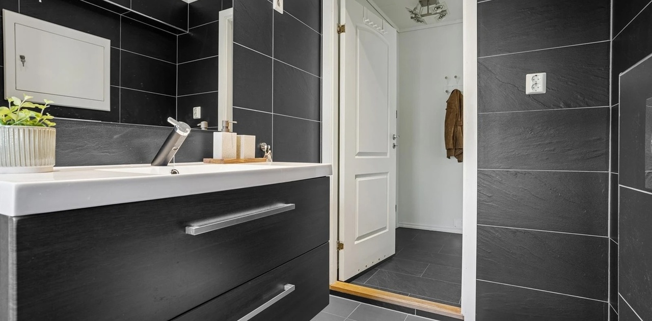 Moderne bad med stor dusjnisje, med vindu mot bakhage og Ulriken