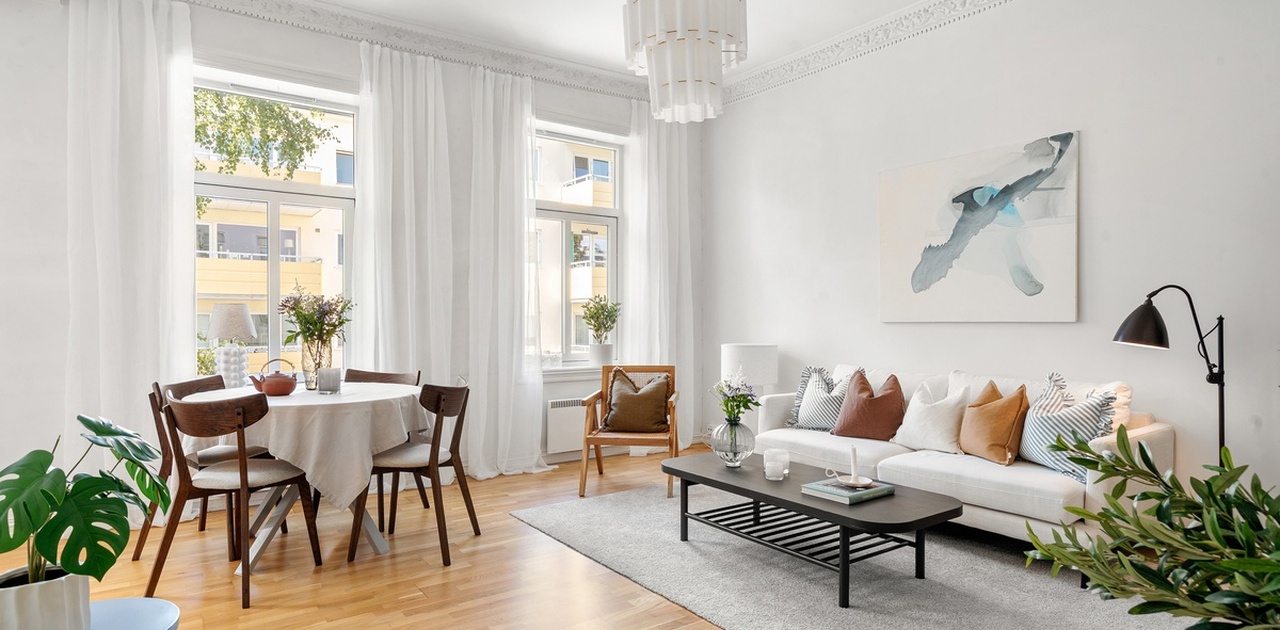 Lys og romslig stue med stukkatur.