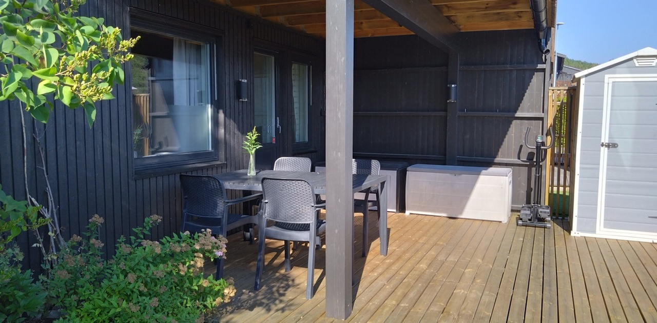 Egen inngang med overbygd terrasse, bord og stoler