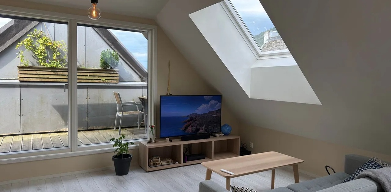 Stue med flotte lysforhold fra terrassedøren og takvinduene