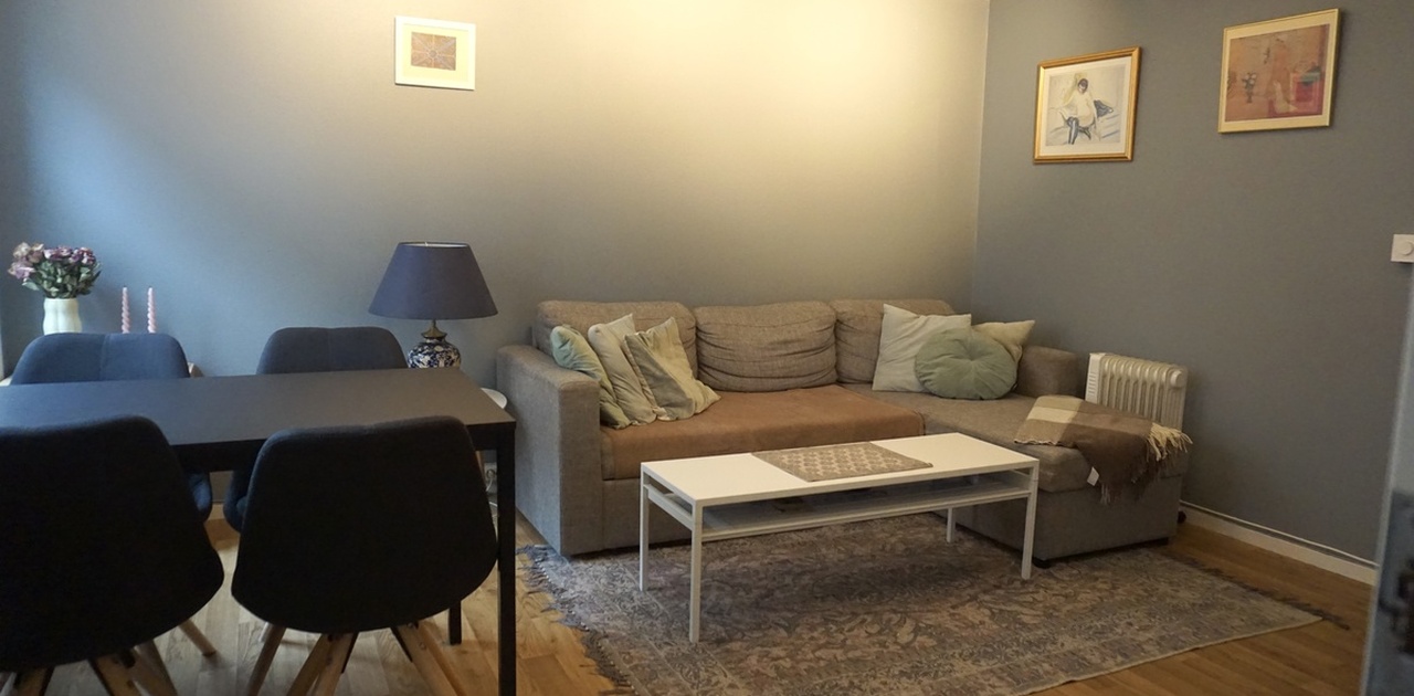 Romslig stue med plass til både sofagruppe og spisebord.