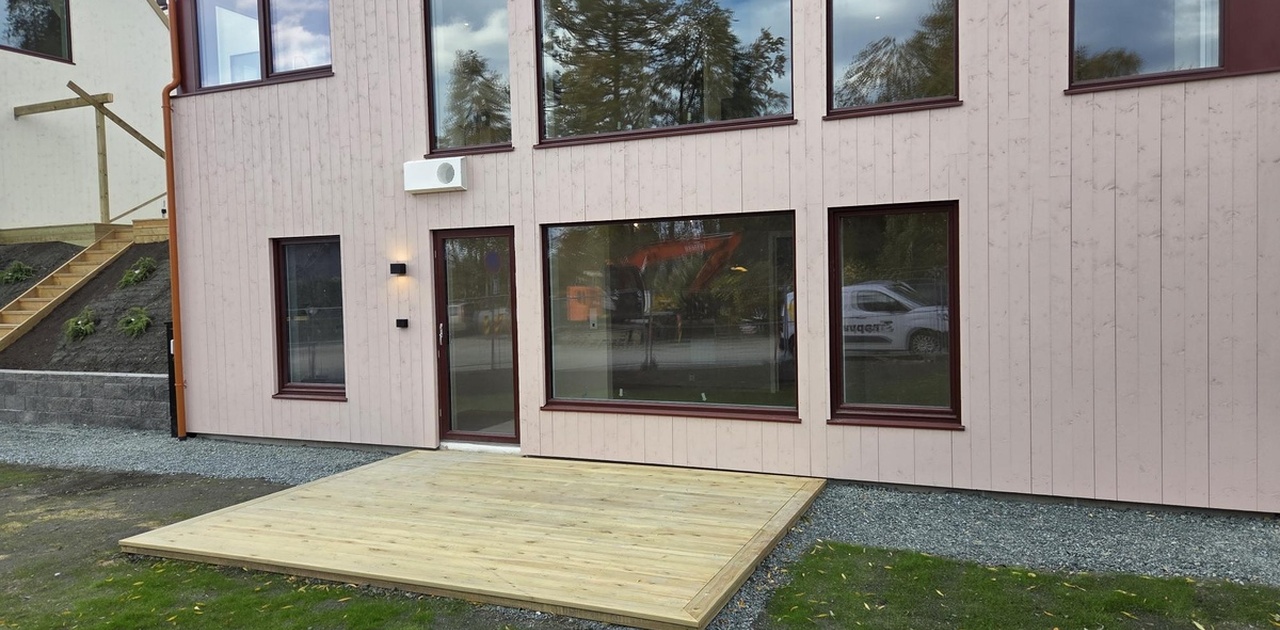 Flott inngangsparti med egen markterrasse. Store vindusflater. Bildet tatt i oktober.