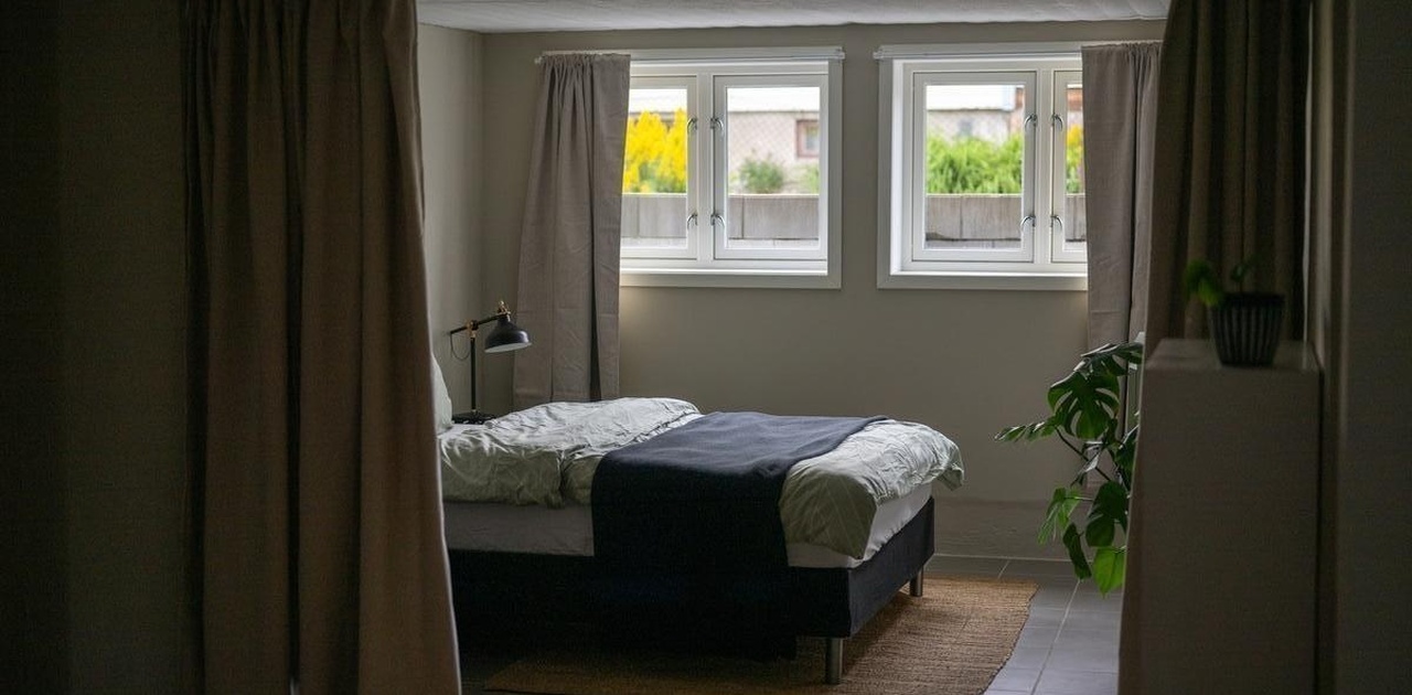 Sovealkove adskilt fra stuen med tykke gardiner. Varmekabler i gulv