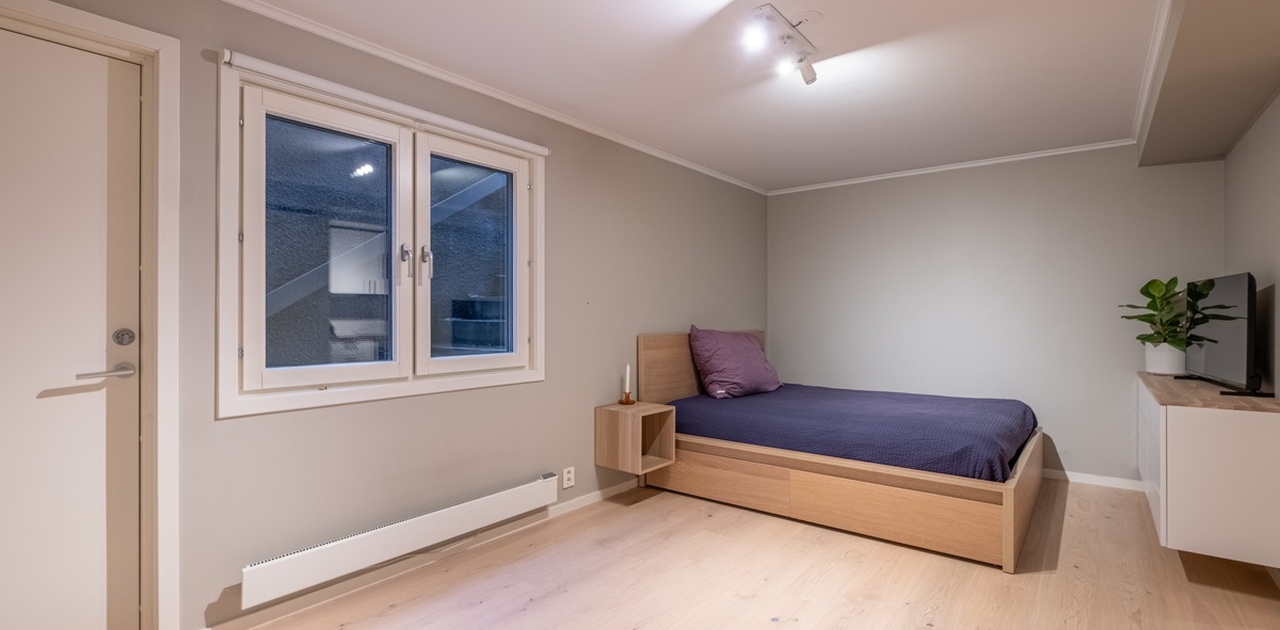 Romslig stue/soverom, med dobbeltseng. Sengen har praktiske skuffer til oppbevaring.