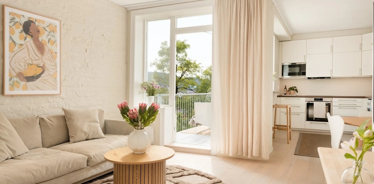 Lys og luftig stue på 24,8 m², malt i i en tidsriktig farge som komplimenteres av et flott 1-stavs parkettgulv.