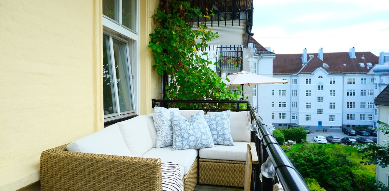 Stor, solrik og vestvendt balkong med hyggelig utsikt mot bakgård og frodige trær på sommerhalvåret.