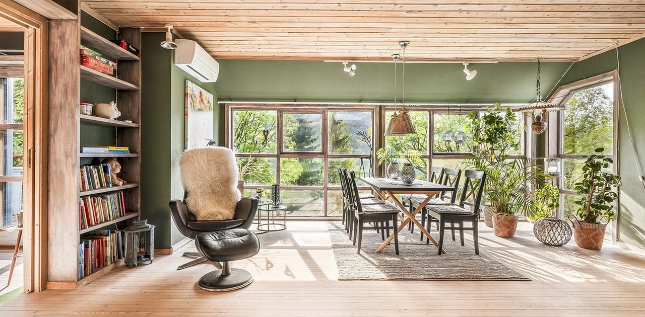 Stue med mye lysinnslipp, utsikt og varmepumpe som sikrer stabil temperatur og et godt inneklima.