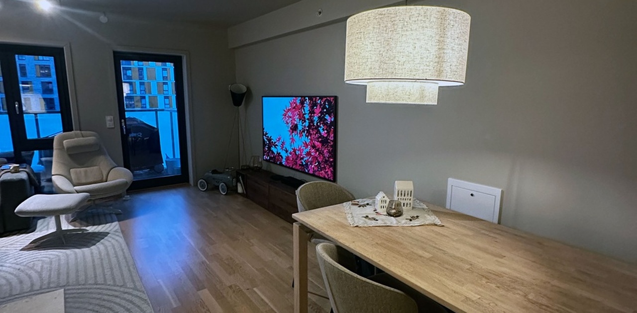 Stor og hyggelig stue med åpen løsning mot spiseplass og utgang til balkong.