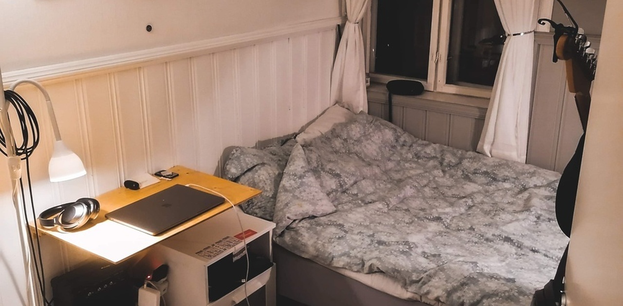 møblert med seng, rullegardin/gardiner og skrivebord.