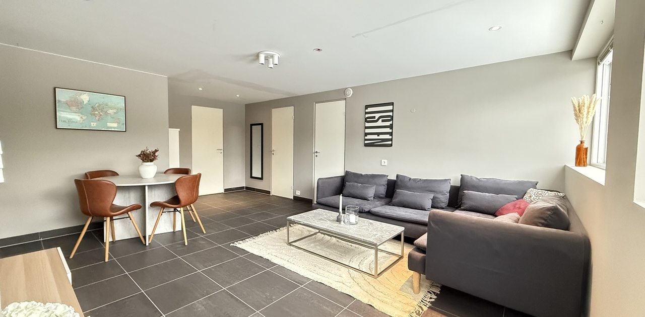 Romslig flislagt stue med innlagte spotlights i himling.