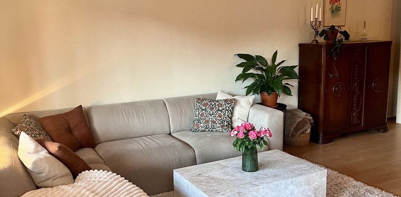 Koselig sofakrok med store vindusflater ut mot balkongen