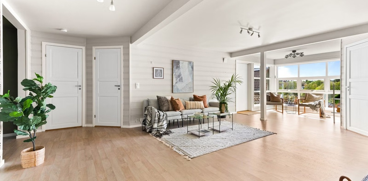 Stue har store vinduer som slipper inn mye naturlig lys