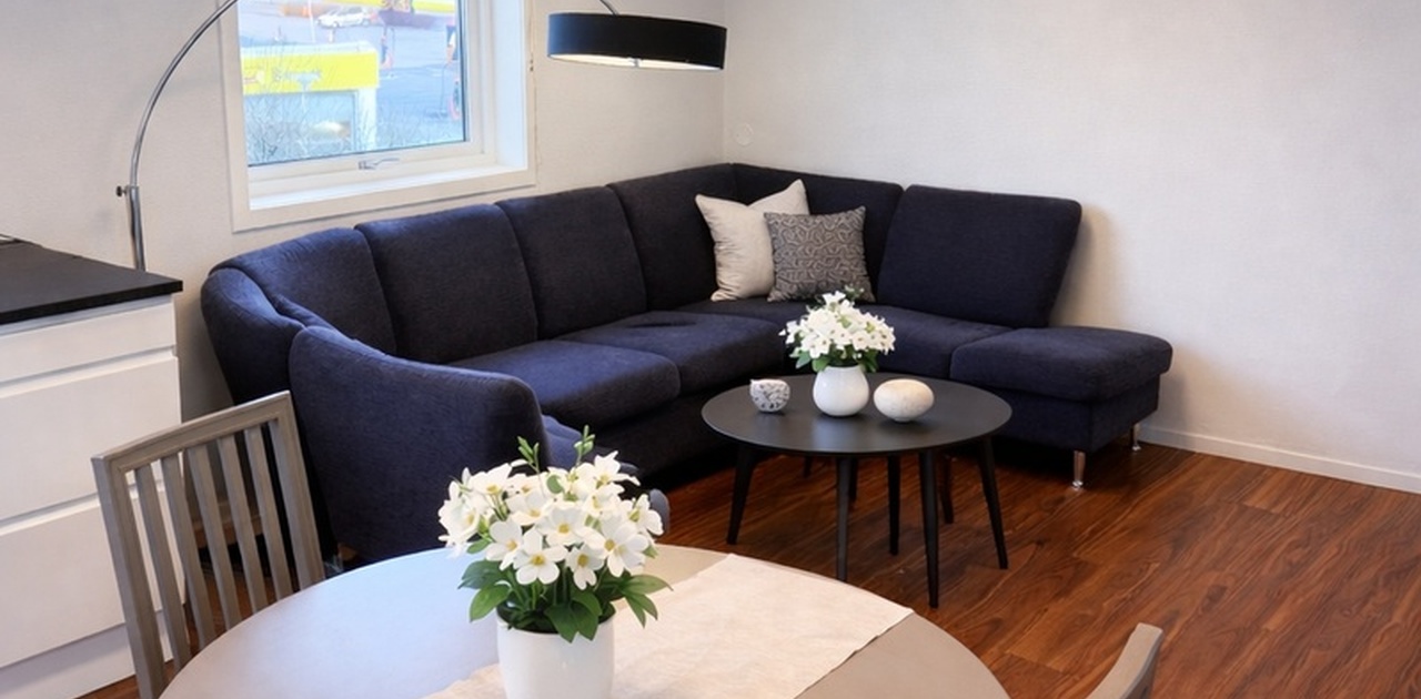 Lys stue med sittegruppe og spiseplass.