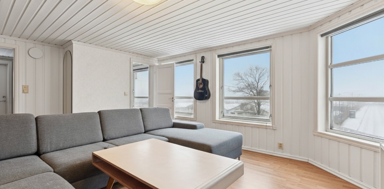 Store vinduer gir rikelig med naturlig lys til stue.