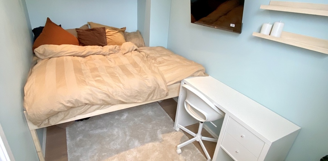 Soverom med smart-tv og skrivebord