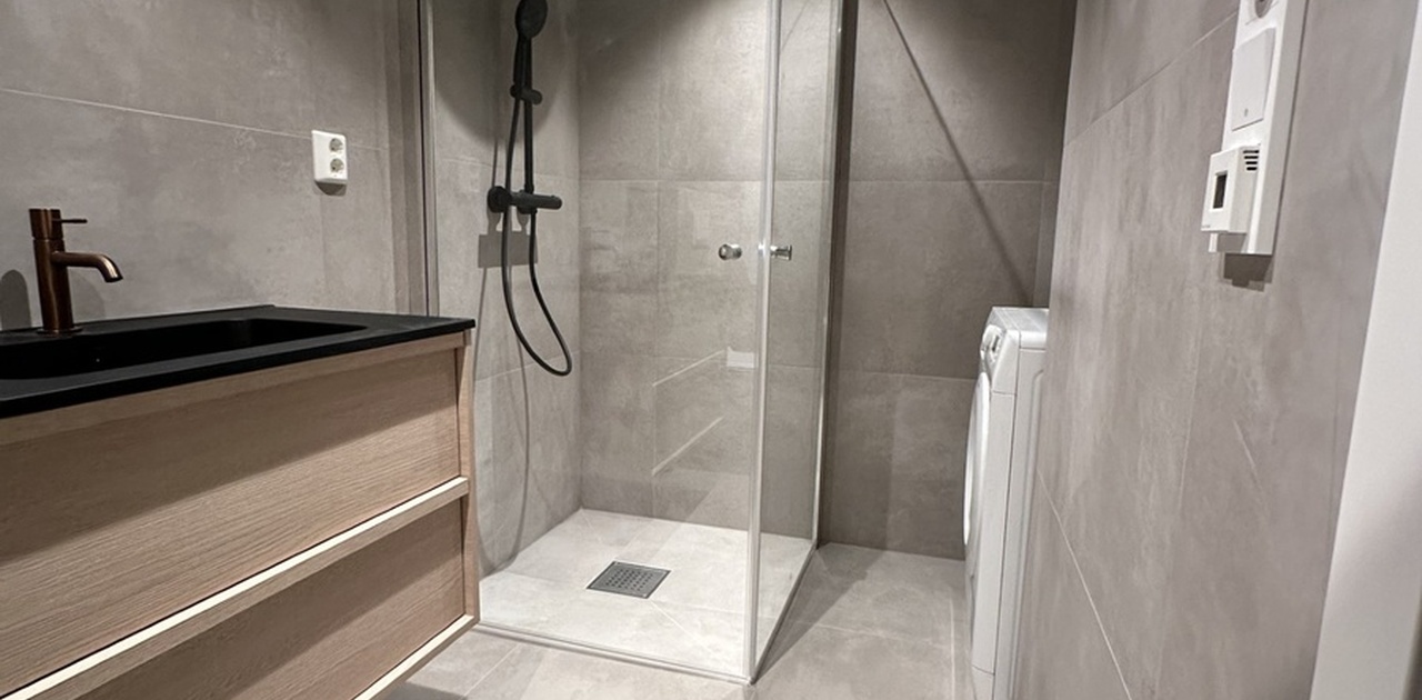 Nytt og ubrukt bad med dusjhjørne og vaskemaskin.