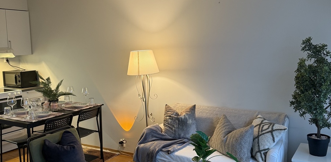 The apartment’s elegant dining area, refined sitting room, and a glimpse of the fully equipped kitchen.