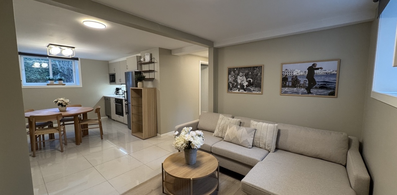 Hyggelig stue del med hjørnesofa, stol og TV