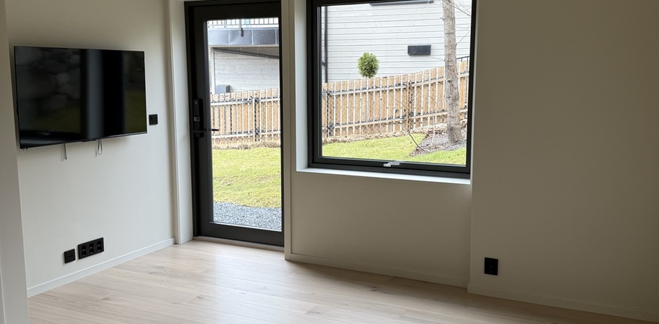 En helt ny QLED TV fra TCL er montert på veggen. Plisségardin til dør og hotellgardiner til vindu er bestilt.