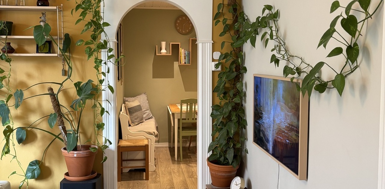 Sjarmerende stue med bue inn til kjøkkenet.