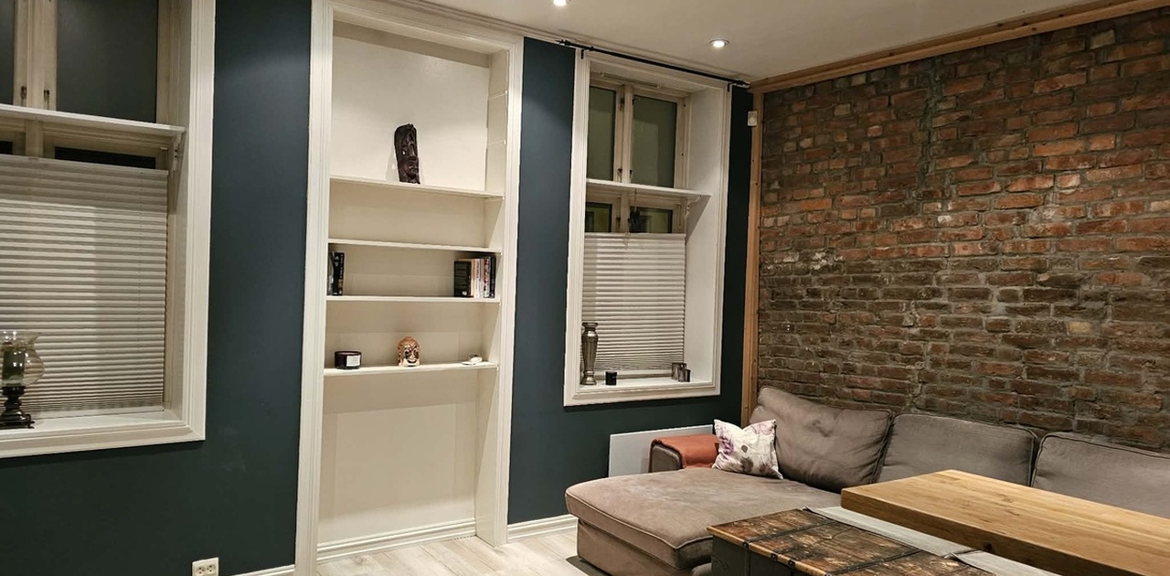 Sjarmerende stue med mursteinsvegg.