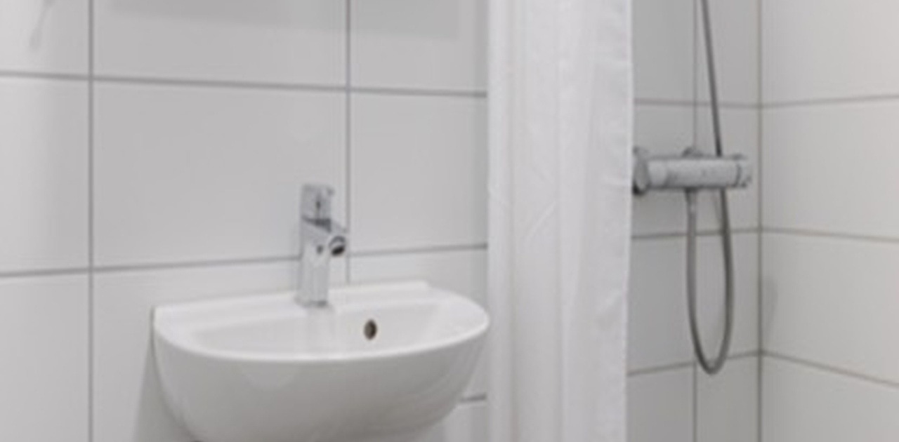 Rommet har eget bad med dusj. (Bildet viser et tilsvarende bad.)