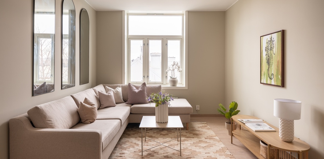 Lys og innbydende stue med store vindusflater som slipper inn godt med dagslys. Perfekt rom for både avslapning og sosiale samvær.