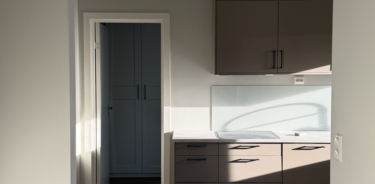 Fullt utstyrt kjøkken med integrerte hvitevarer.