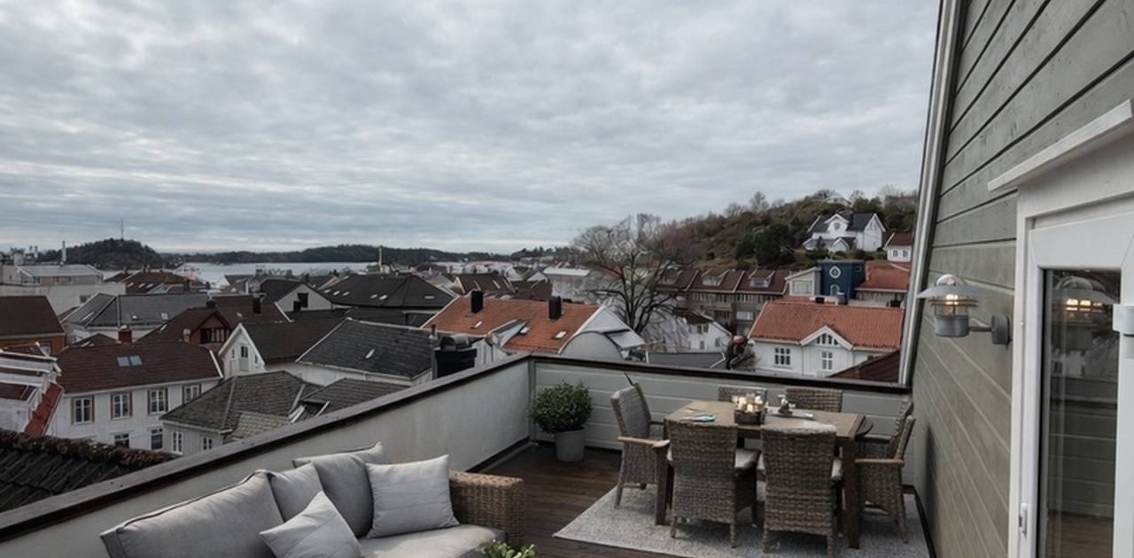 Stor terrasse med utsikt over byen og ned til sjøen